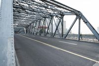 the bridge is spanning two lanes on the left side with trucks and trucks behind it