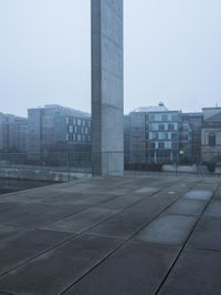 the obelisk is visible in this scene, in a foggy background of urban buildings