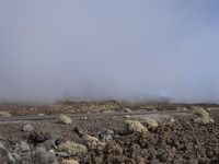 a road near the mountain side in the foggy sun day, and on the opposite bank are hills