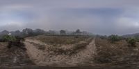 an intersection view of a road in the middle of nowhere with fog rolling in overhead