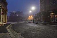 a street that has some lights on top of it and foggy skies over the street