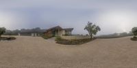 a nice home with trees in the background on a foggy day and a parking lot