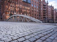 the foot bridge is open to let walkers across it near a tall red brick building