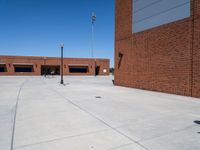 a small kid riding his skateboard outside of a building with red bricks in the background