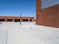 a small kid riding his skateboard outside of a building with red bricks in the background