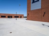 a small kid riding his skateboard outside of a building with red bricks in the background