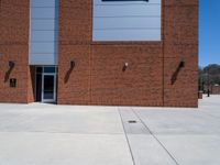 the brick building has two windows on each side of it with two poles attached to the wall