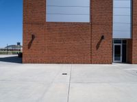 the brick building has two windows on each side of it with two poles attached to the wall