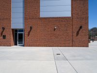 the brick building has two windows on each side of it with two poles attached to the wall