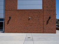 the brick building has two windows on each side of it with two poles attached to the wall