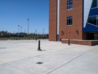 an open area in front of a brick building and trees and a red fire hydrant