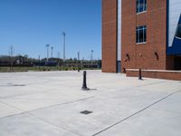 an open area in front of a brick building and trees and a red fire hydrant