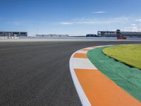 the green road and orange and white stripe line at an event near the racetrack and stadium