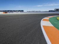 the green road and orange and white stripe line at an event near the racetrack and stadium