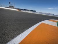 the green road and orange and white stripe line at an event near the racetrack and stadium