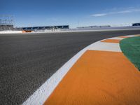 the green road and orange and white stripe line at an event near the racetrack and stadium