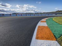 the green road and orange and white stripe line at an event near the racetrack and stadium