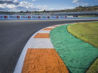 the green road and orange and white stripe line at an event near the racetrack and stadium