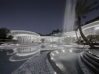 a modern building with a fountain in front of it and steps leading up to the pool