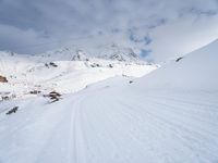 a skier traveling down a slope with a snowboard attached to their legs and head in the air