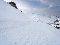 a snow covered mountain with ski tracks leading to it's top slope in winter