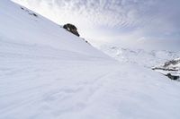 a snow covered mountain with ski tracks leading to it's top slope in winter