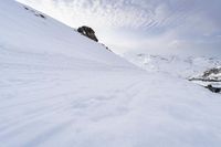 a snow covered mountain with ski tracks leading to it's top slope in winter