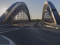 a crosswalk on a bridge that is made out of steel plates and curved beams