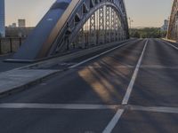 a crosswalk on a bridge that is made out of steel plates and curved beams