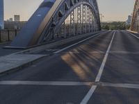 a crosswalk on a bridge that is made out of steel plates and curved beams