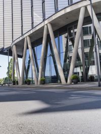 an intersection on the street and people passing by in the reflection of it on the windows of a building