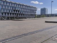 a train tracks that is on the road in front of buildings and some people on a platform