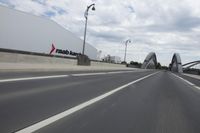 a large bridge over the road with trees in the background while traffic moves down it