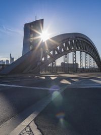 the sun shines brightly on a bridge over a highway in a city, as seen from the road level