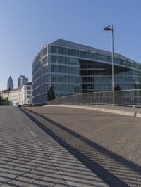 large modern building next to an empty parking lot and street with cars parked on both sides