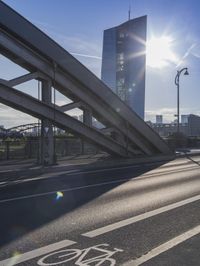 the bike lane is next to the road as the sun shines in the sky