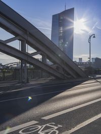 the bike lane is next to the road as the sun shines in the sky