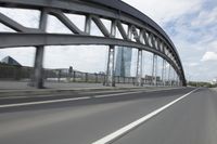a view from a speeding car looking down the highway toward some buildings on the side of the road