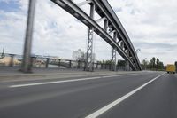 a view from a speeding car looking down the highway toward some buildings on the side of the road