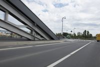 a view from a speeding car looking down the highway toward some buildings on the side of the road