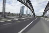 a view from a speeding car looking down the highway toward some buildings on the side of the road