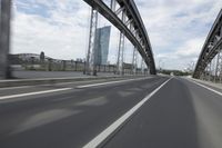 a view from a speeding car looking down the highway toward some buildings on the side of the road