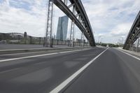 a view from a speeding car looking down the highway toward some buildings on the side of the road