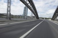 a view from a speeding car looking down the highway toward some buildings on the side of the road