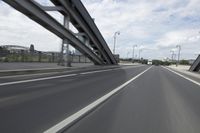 a view from a speeding car looking down the highway toward some buildings on the side of the road