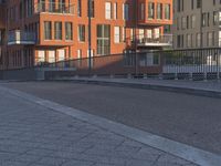a city side street has no people walking and no cars on it, including one man skateboarding
