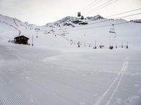 a snowy area covered in snow and ski lift on top of a mountain covered in snow