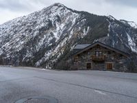 a house is in the middle of the road, and a mountain in the background