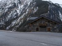 a house is in the middle of the road, and a mountain in the background