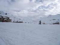 a group of people are skiing down the slope on a sunny day at a resort